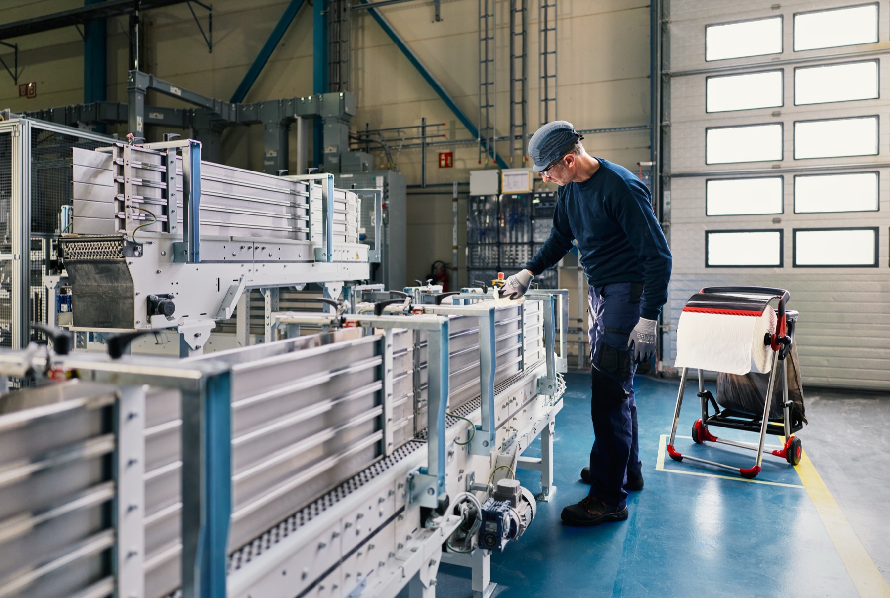 Medewerker bij de productielijn met een Tork-trolley in de fabriekshal